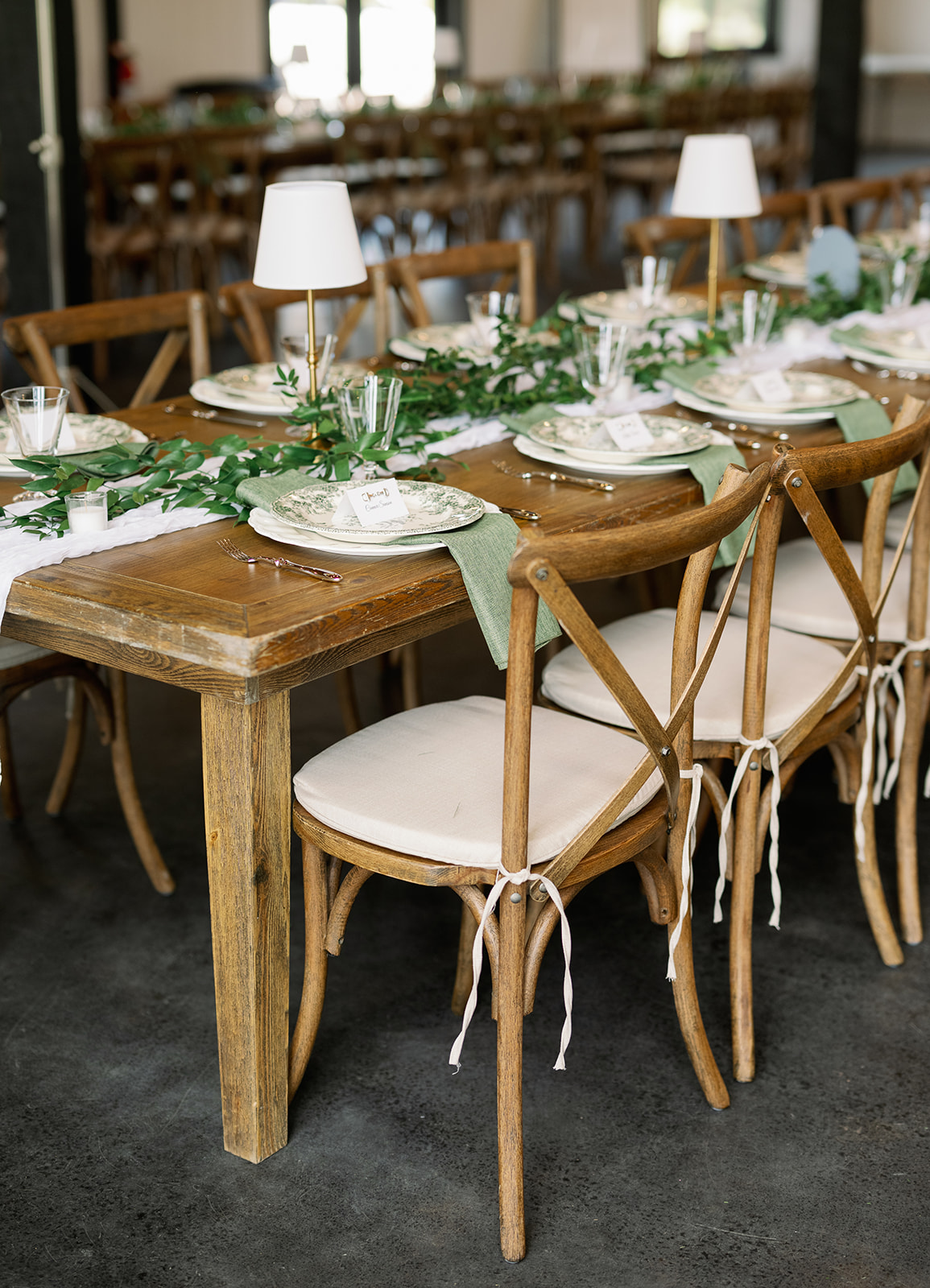 Place setting detail with greenery and candlelight